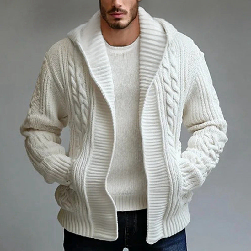 Man wearing a white cable knit cardigan over a white sweater on a gray background