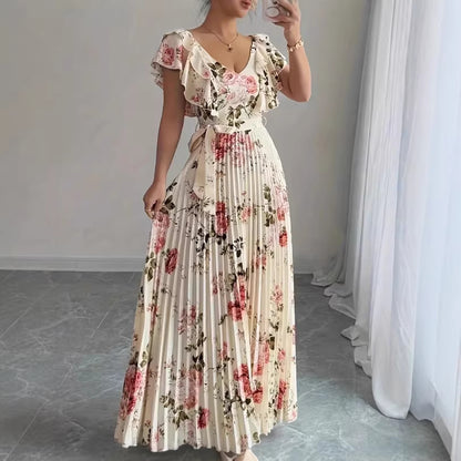 Woman wearing a floral dress in a room with white curtains.
