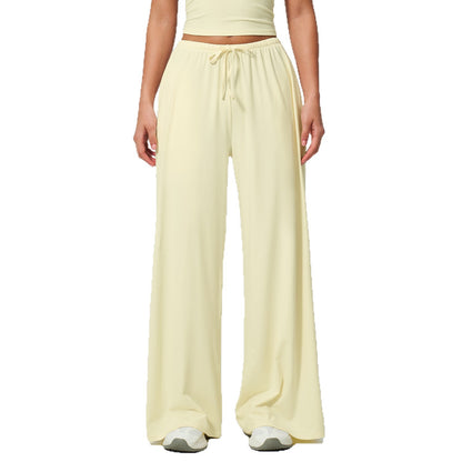 Person wearing light yellow wide-leg pants on a white background