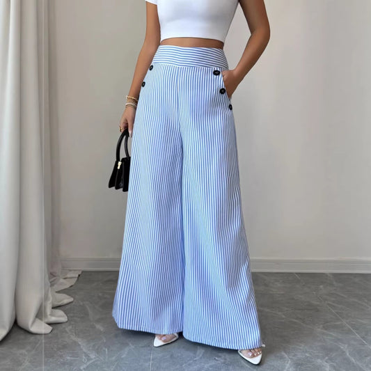 Person wearing blue and white striped pants with a white top, standing against a neutral background.